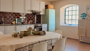 A kitchen with white cabinets, a brick backsplash, and a window with a view.