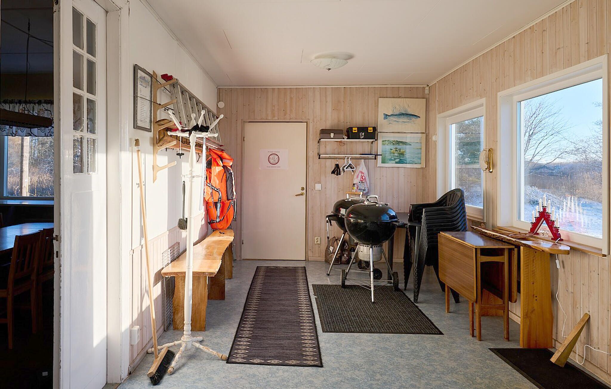 Kompakti keittiö, jossa on puiset kaapit, ruokapöytä ja ikkuna, josta avautuu näkymä lumiseen maisemaan.