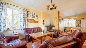Una sala de estar acogedora con sofás de cuero, una mesa de centro de madera y una chimenea.
