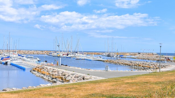 A marina with boats docked, a rocky shoreline, and a clear sky. - 3 bedroom nice home in Simrishamn (Simrishamn)