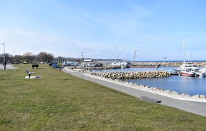 A marina with boats docked, a walking path, and a grassy area with benches. - Beautiful home in Simrishamn (Simrishamn)