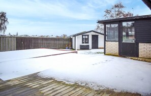 A covered outdoor area with a wooden deck, a small shed, and a fenced yard. - Beautiful home in Simrishamn (Simrishamn)