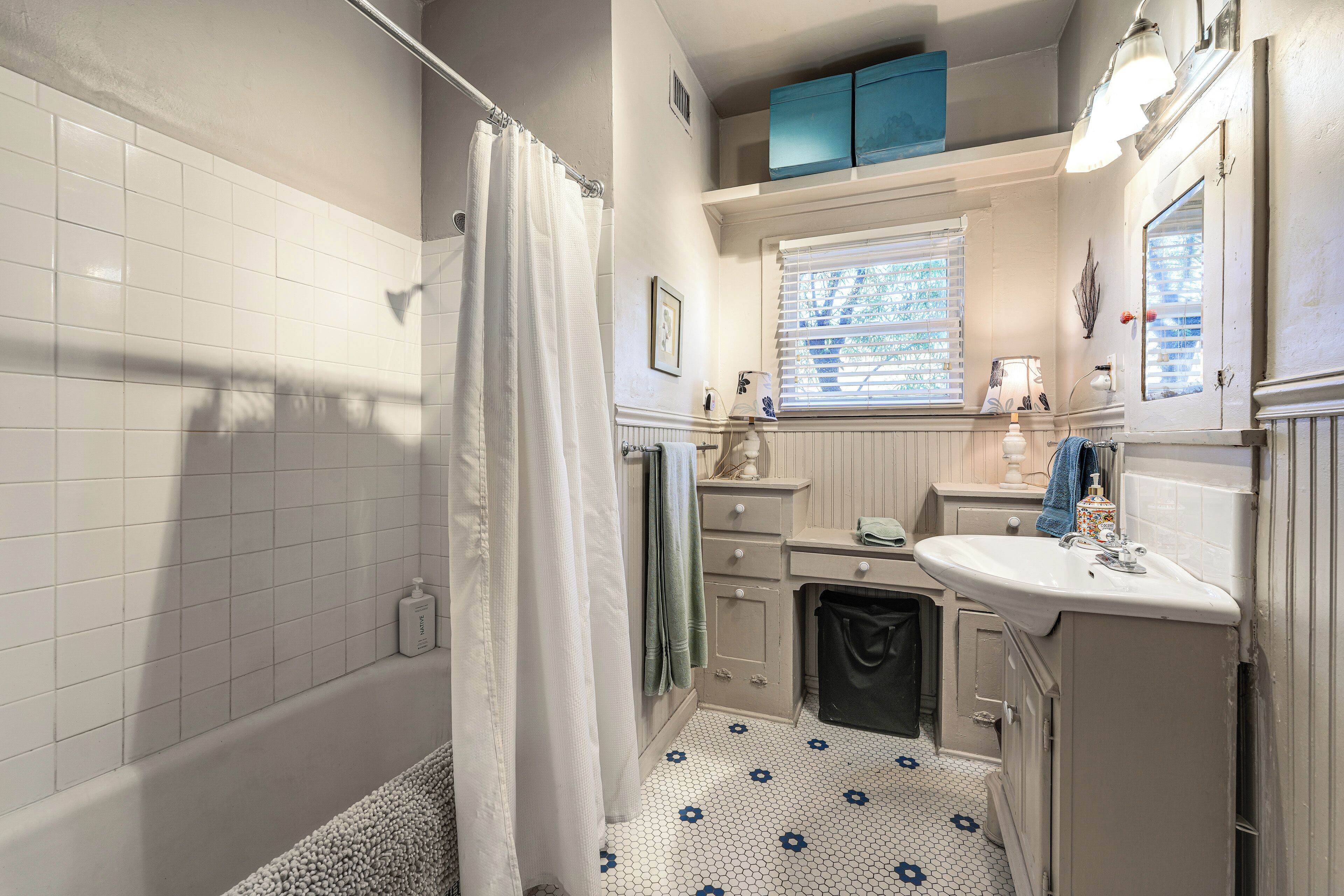 A bathroom with a bathtub, a sink, and a window.
