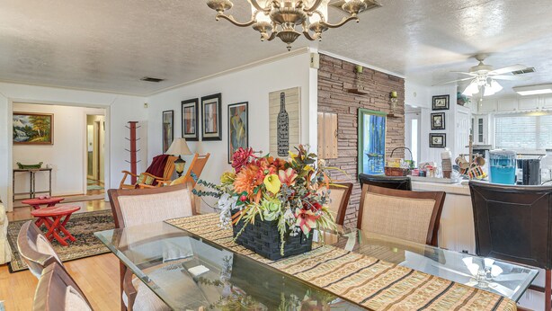 A dining area with a glass table, cushioned chairs, and a floral centerpiece. - Shop, Dine & Explore: Home 3 Mi to NRG Stadium (Houston)