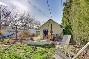 Ein kleines Haus mit Garten, Sitzgelegenheit im Freien und einer Hängematte.