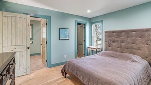 Une chambre à coucher avec un grand lit, une armoire en bois et une petite table.