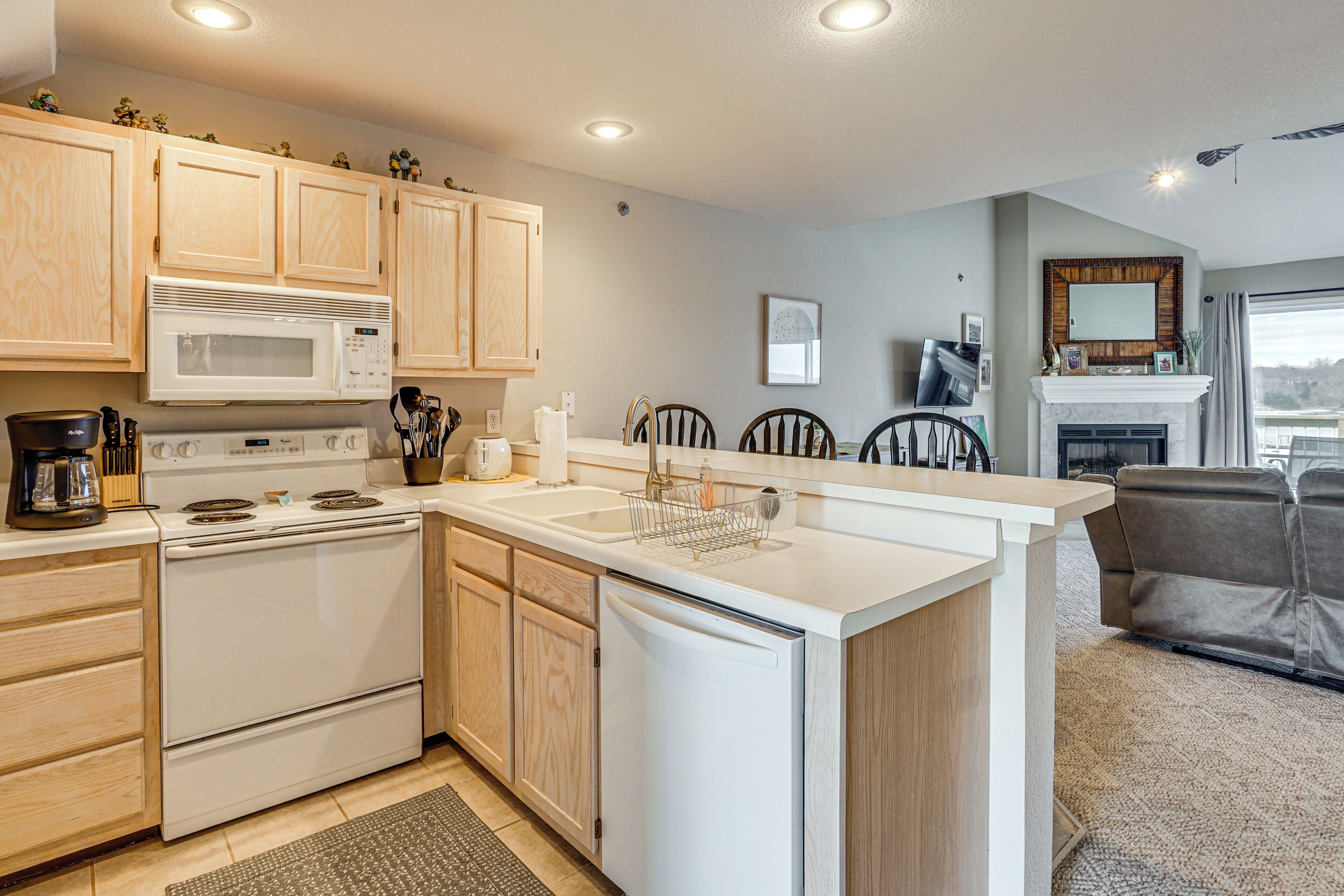 A modern kitchen with wooden cabinets, a white stove, and a built-in microwave.