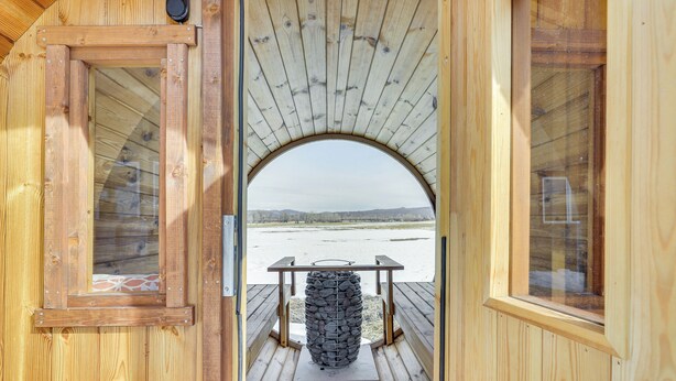 A wooden cabin with a large arched window and a rustic interior. - Fish, Hike & Ski: Mtn-view Gunnison Home w/ Sauna (Gunnison)