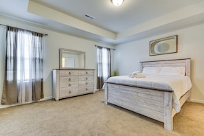 A bedroom with a bed, a dresser, a mirror, and a ceiling light. - 4 Mi to Hospital & Dtwn Greensboro: Spacious Home (Greensboro)