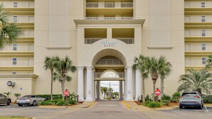 A hotel entrance with a sign reading "Chateau Dunes." There are palm trees and a brick pathway leading to the entrance. - Steps to Sea! Snowbird Haven in Miramar Beach (Miramar Beach)
