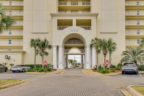 A hotel entrance with a sign reading "Chateau Dunes." There are palm trees and a brick pathway leading to the entrance. - Steps to Sea! Snowbird Haven in Miramar Beach (Miramar Beach)