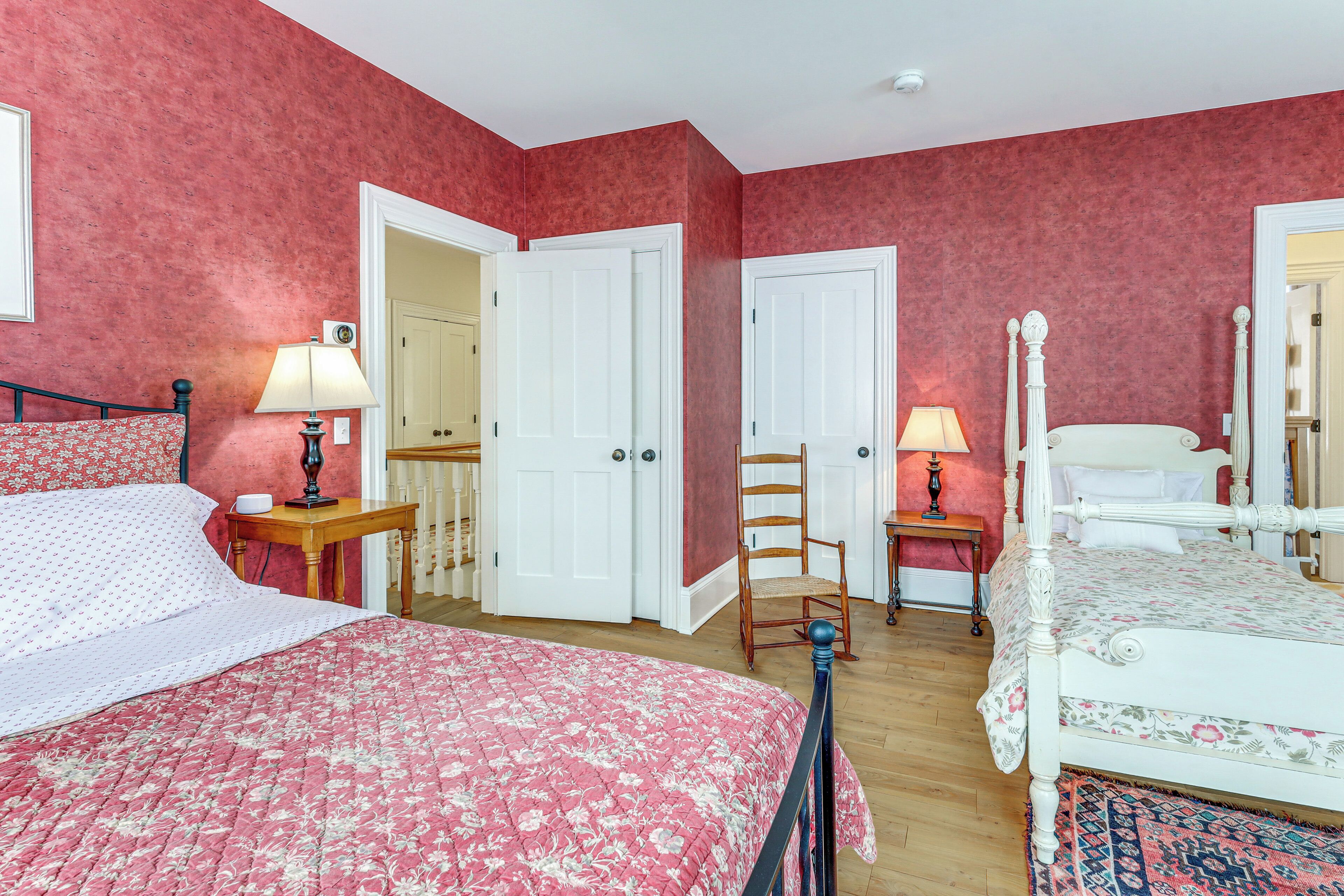 A bedroom with a large bed, two bedside tables, a chair, and a wardrobe.