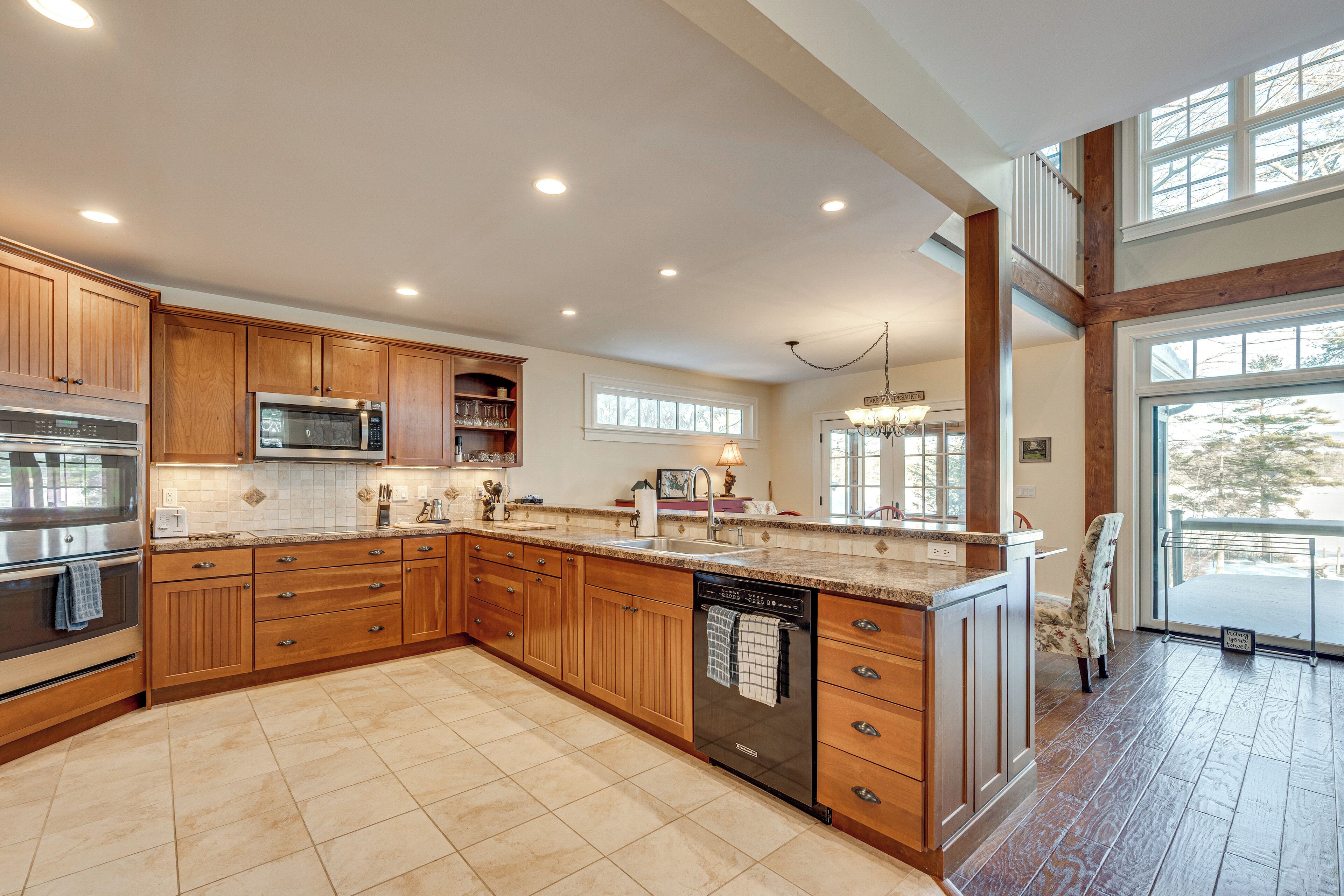 A spacious kitchen with wooden cabinets, stainless steel appliances, and a large island.