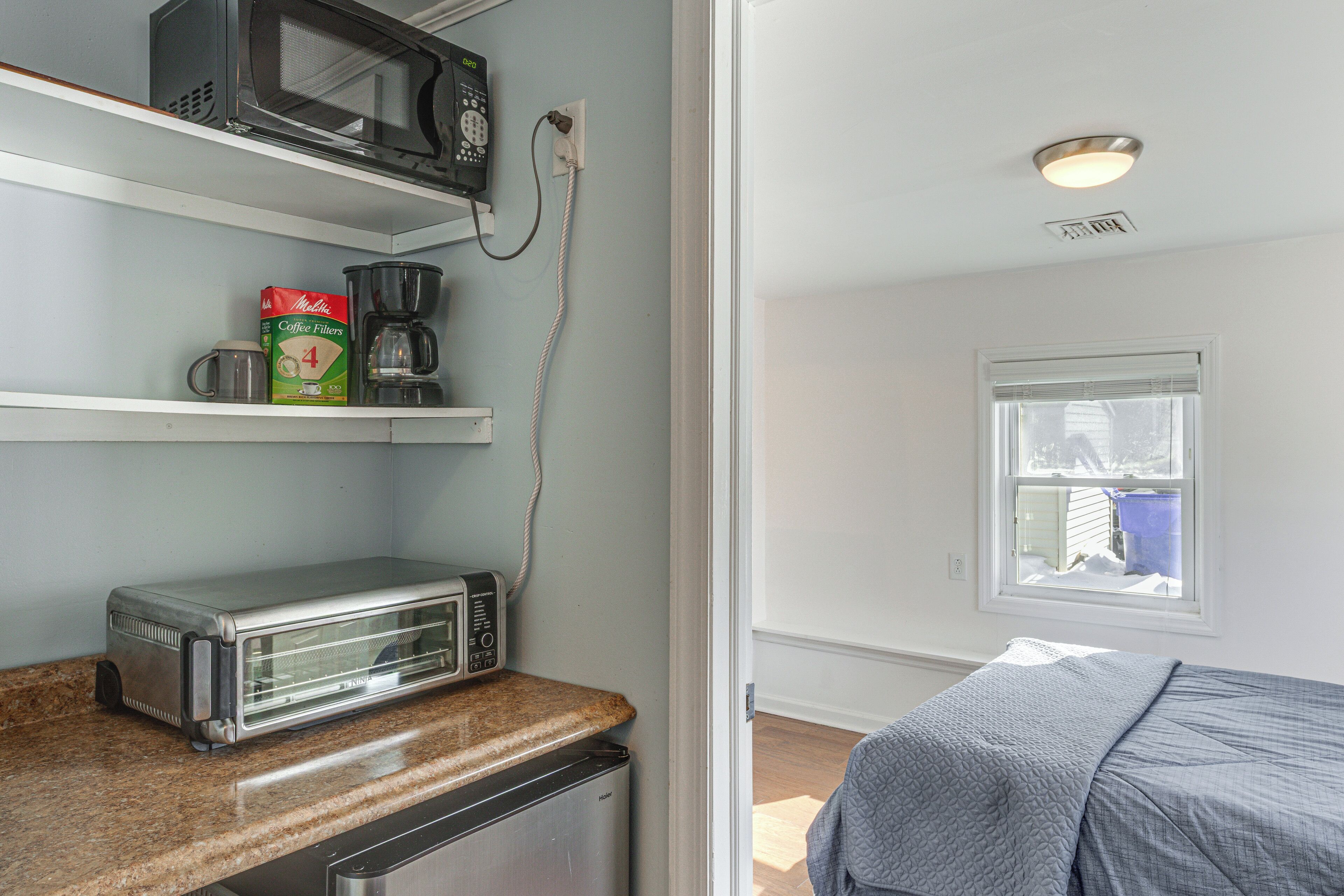 A kitchen with a toaster, coffee maker, and coffee filters on the counter.