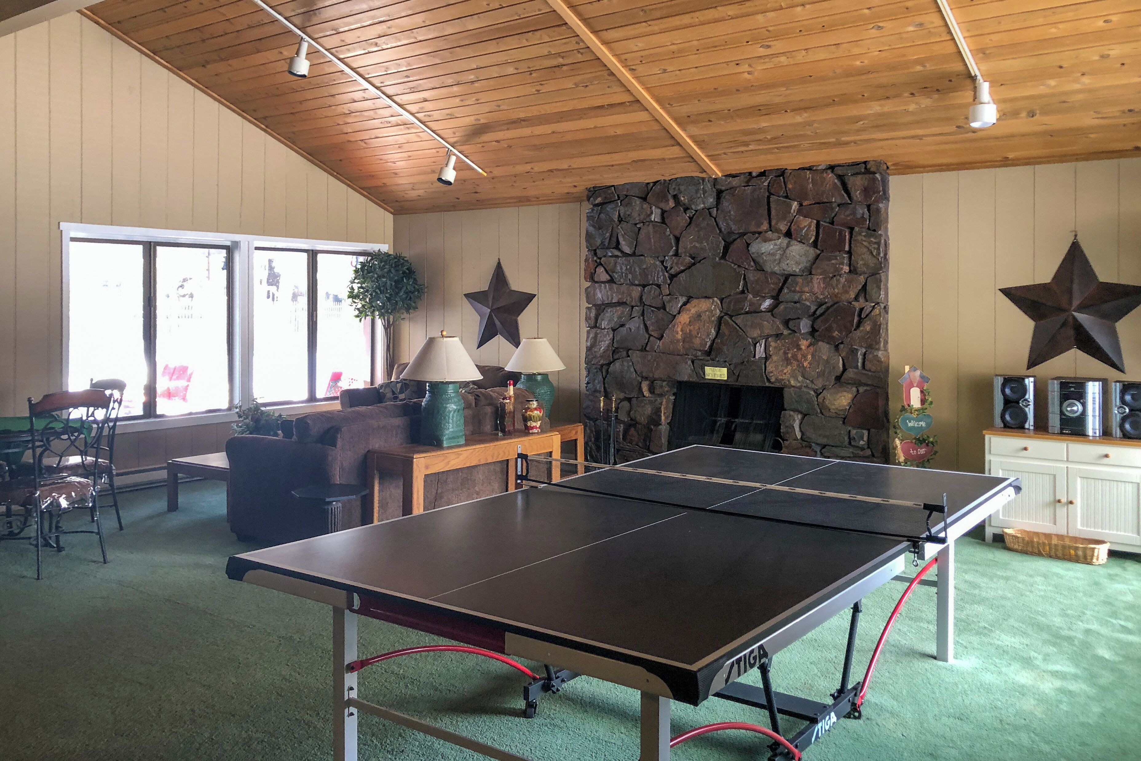 Et værelse med et ping pong bord, en stensokkel og en stjernepynt.