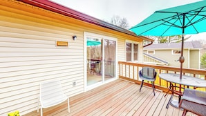 A wooden deck with a table and chairs, a sliding glass door, and a green umbrella. - 3 Mi to IU! Family-friendly Bloomington Home (Bloomington)