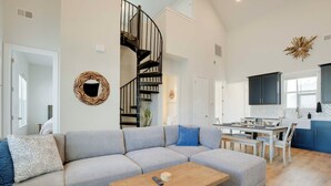 A modern living room with a gray sectional sofa, a wooden coffee table, and a spiral staircase. - Great for Boating & Fishing! Lake Greenwood Escape (Greenwood)