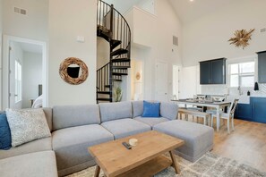 A modern living room with a gray sectional sofa, a wooden coffee table, and a spiral staircase. - Great for Boating & Fishing! Lake Greenwood Escape (Greenwood)