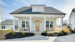 A two-story house with a front porch, two windows, and a door. - Steps to Marina! Lake Greenwood Home w/ Patios (Greenwood)