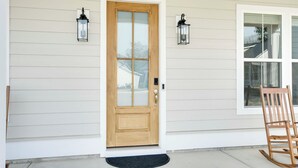 A wooden front door with a glass panel, flanked by two wall-mounted lanterns. - Steps to Marina! Lake Greenwood Home w/ Patios (Greenwood)