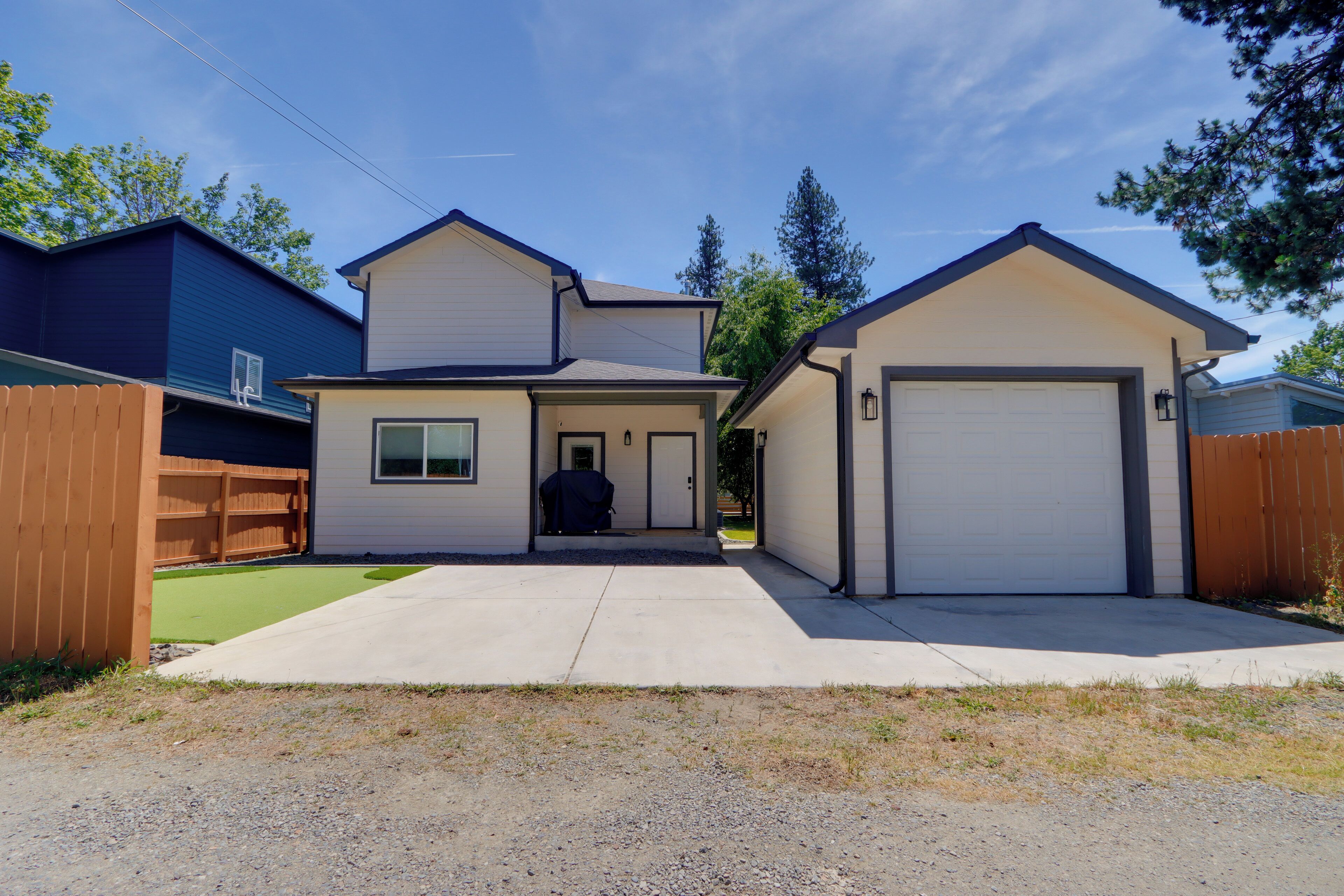 A two-story house with a garage, a covered porch, and a lawn.