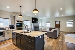 A spacious living area with a large island, a fireplace, and a sofa.