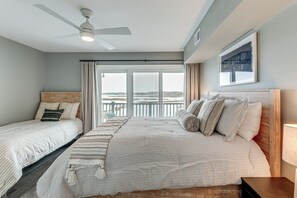 A bedroom with two beds, a ceiling fan, a large window with curtains, and a framed motivational quote on the wall. - 1 Mi to Fenwick Island SP: Condo w/ Boat Dock! (Selbyville)