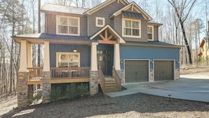 A two-story house with a stone foundation, a front porch, and a garage. - Lake Lure Getaway w/ Hot Tub & Fire Pit! (Lake Lure)