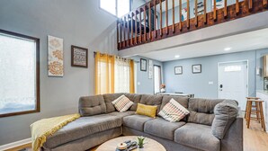 A living room with a sectional sofa, a coffee table, and a staircase leading to an upper level. - Family Getaway w/ Deck Near Tobyhanna State Park (Tobyhanna)