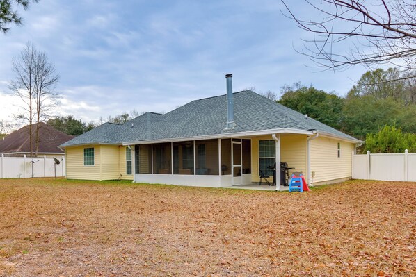 A single-story house with a covered porch, a chimney, and a fenced yard. - 11 Mi to Savannah! Suburban Home w/ Spacious Yard (Pooler)