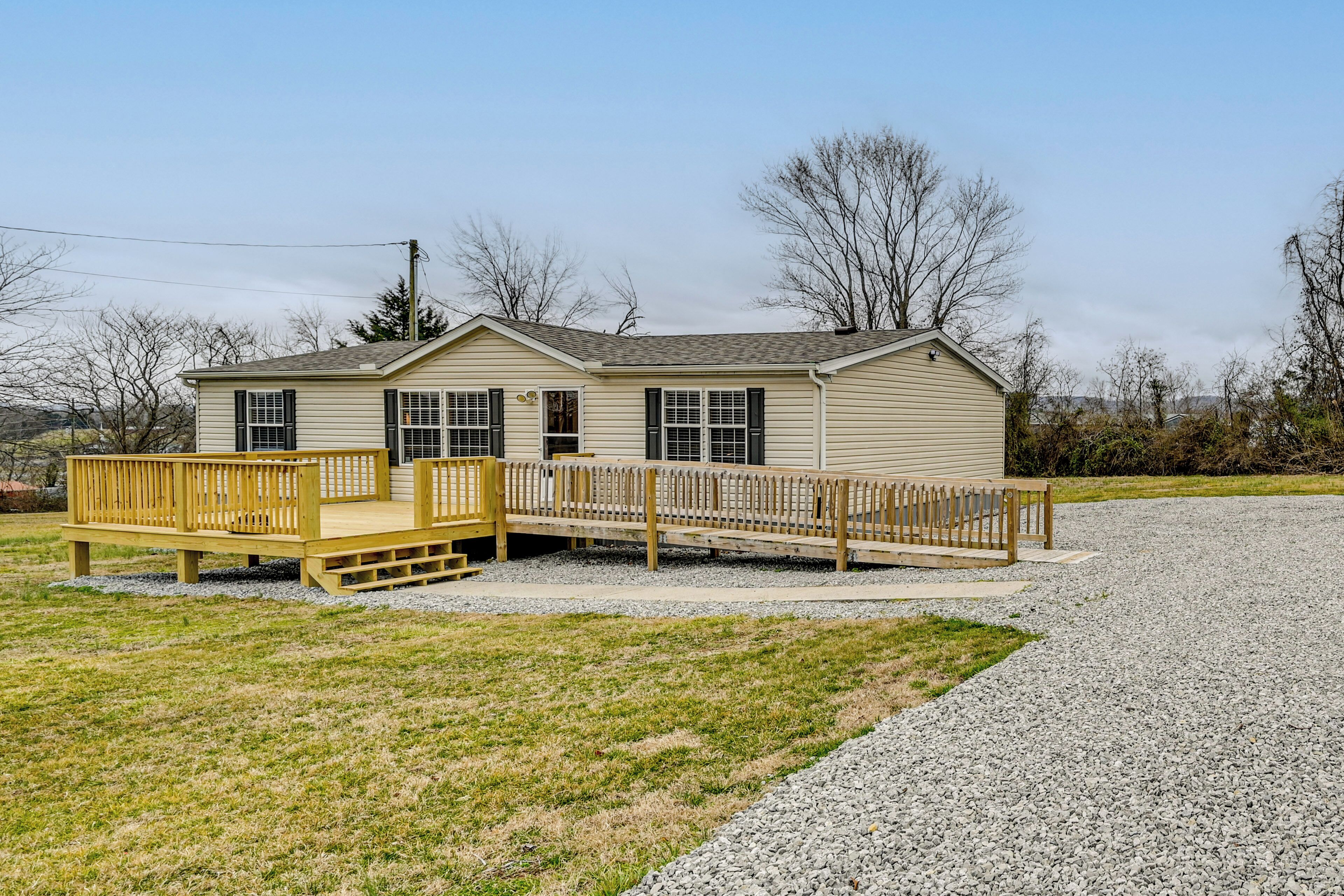 A single-story building with a covered deck and a gravel driveway.