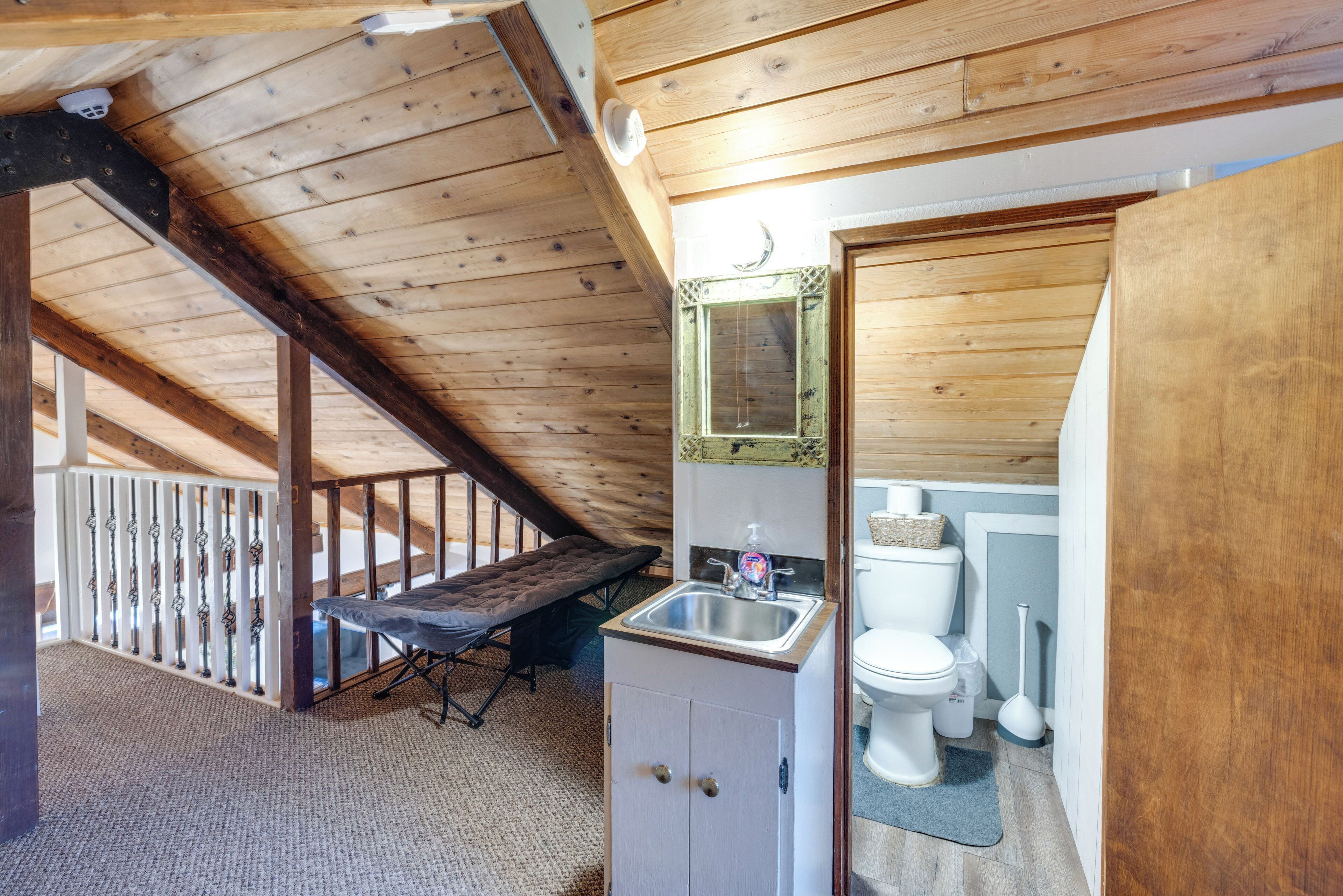 A wooden interior with a bench, a small sink, and a toilet.