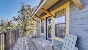 A wooden deck with two Adirondack chairs, a door with a window, and a railing. - Pool Access, Walk to Water! Possum Kingdom Cabin (Graford)