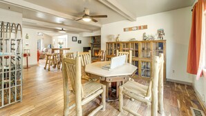 A dining area with a wooden table and chairs, a ceiling fan, and a bookshelf. - Great for Families! Woodsy Haven in Happy Jack (Happy Jack)