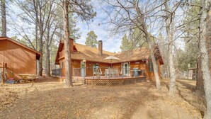 A rustic cabin with a wooden exterior, a covered porch, and a wheelbarrow near the entrance. - Great for Families! Woodsy Haven in Happy Jack (Happy Jack)