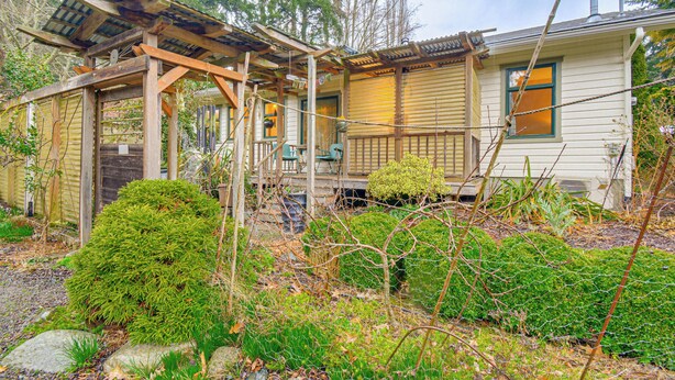 A house with a covered porch, a small garden, and a wooden deck. - Walk to Irondale Beach Park! Family Haven w/ Yard (Port Hadlock)
