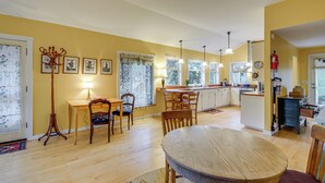 A bright kitchen with wooden cabinets, a dining area with a round table, and a ceiling fan. - Walk to Irondale Beach Park! Family Haven w/ Yard (Port Hadlock)