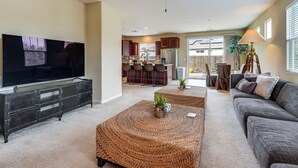 A living room with a large flat-screen TV, a ceiling fan, and a sofa. - Sophisticated Sanctuary: 8 Mi to Lodi Wineries! (Stockton)