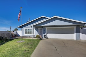 Ein Wohnhaus mit Garage, Rasen und einer amerikanischen Flagge.