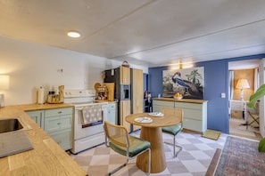 A compact kitchen with a dining area, featuring a wooden table, chairs, and a refrigerator. - < 1 Mi to Dtwn Brandon! Cozy Home w/ Fenced Yard (Brandon)