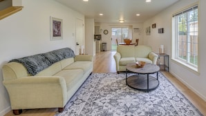 A spacious living room with a beige sofa, a patterned rug, and a round coffee table. - Dog-friendly Townhome Near Stillaguamish River! (Arlington)