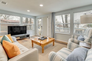 A living room with a sofa, a coffee table, and a television.