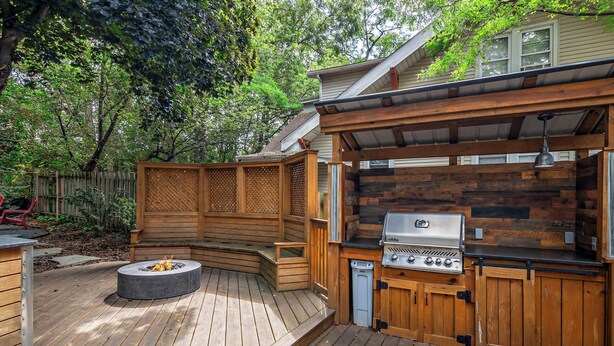 A wooden deck with a built-in grill and fire pit. - Walk to Fox River Grove Station: Home w/ Hot Tub (Fox River Grove)