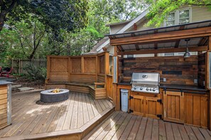 A wooden deck with a built-in grill and fire pit. - Walk to Fox River Grove Station: Home w/ Hot Tub (Fox River Grove)