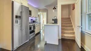 A kitchen with a stainless steel refrigerator, built-in oven, and a small island with a sink. - Walk to Fox River Grove Station: Home w/ Hot Tub (Fox River Grove)