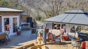 An outdoor patio area with a covered seating area, a fire pit, and a fountain. - Private Hot Tub, Deck & Mtn Views! Hickman Retreat (Hickman)