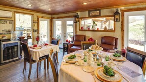 A dining area with a wooden ceiling, a kitchen in the background, and a view of the outdoors. - Private Hot Tub, Deck & Mtn Views! Hickman Retreat (Hickman)