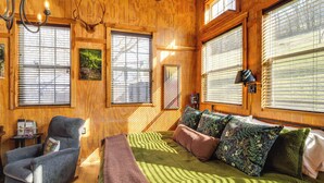 A cozy wooden room with a bed, a chair, and a table. - Private Hot Tub, Deck & Mtn Views! Hickman Retreat (Hickman)