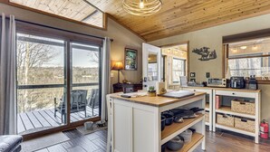 A modern kitchen with a wooden island, large windows, and a view of the outdoors. - Peaceful Nature Retreat w/ Hot Tub in Eastern WV! (Lost River)