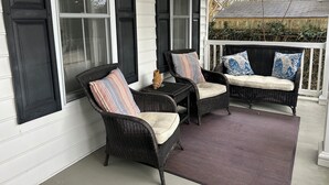 A porch with two wicker chairs and a bench, each with cushions. - In-town Lewes house with great floor plan!  112 Bradley Lane (Lewes)